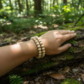 person wearing bracelet -st White tammepuit pärlid