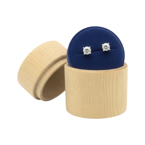 pair  diamond stud earrings in a turned ümar puidust ehtekarp on a beige stand